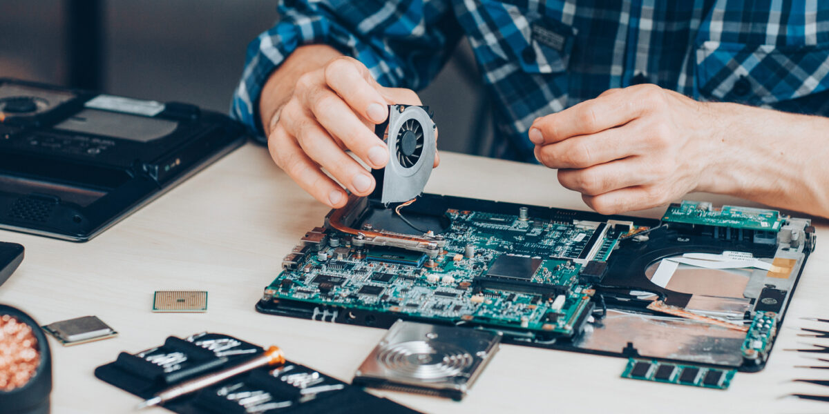 A computer engineer fixing a computer one piece at a time.