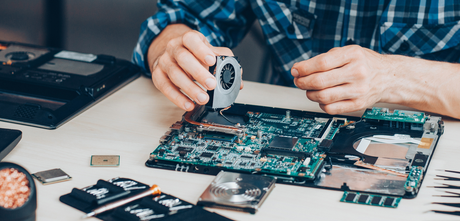 A computer engineer fixing a computer one piece at a time.