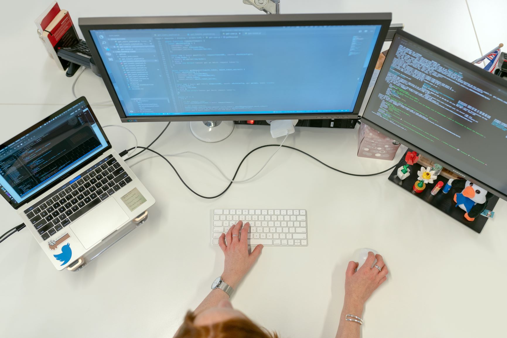 An IT worker setting up synchronization between two desktop and one laptop for a company's data recovery plan.