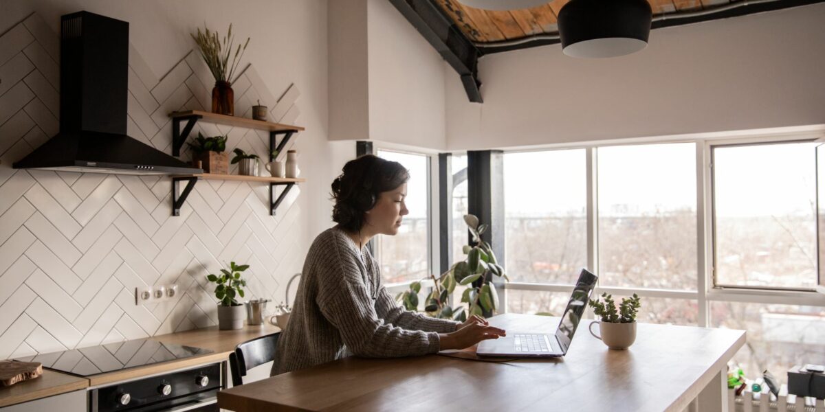 A remote working work from home in their rustic kitchen.