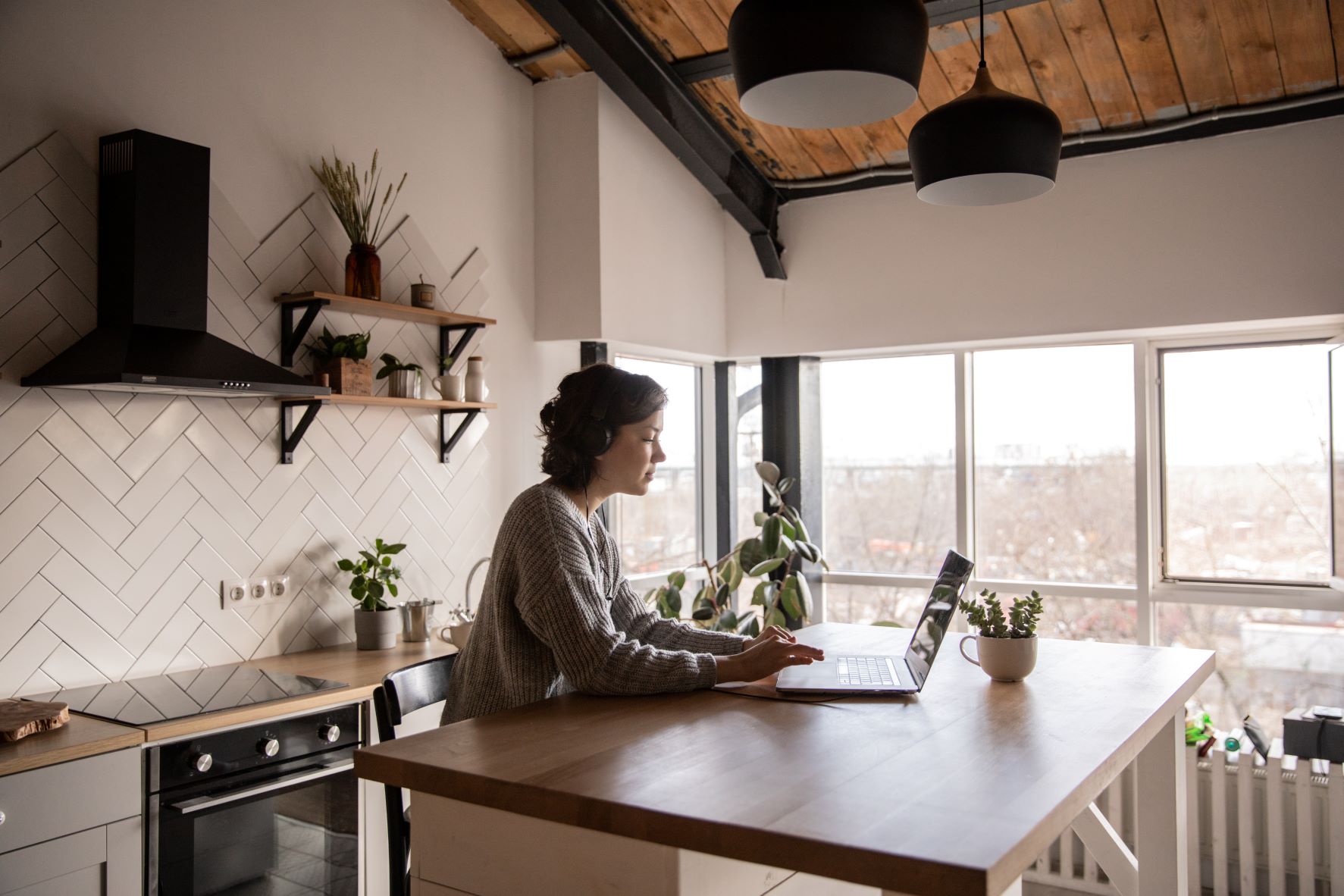 A remote working work from home in their rustic kitchen.