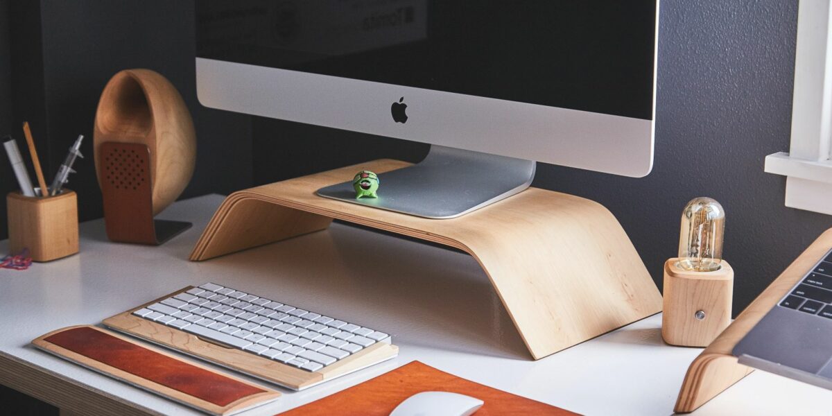 A clean work computer sits on an organized desk with a mouse and keyboard in front of it.