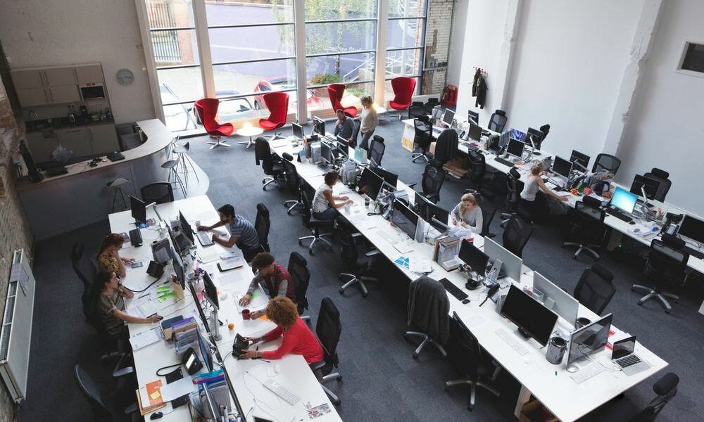 an image of an office with rows of workstations that a managed service provider could help take care and manage.