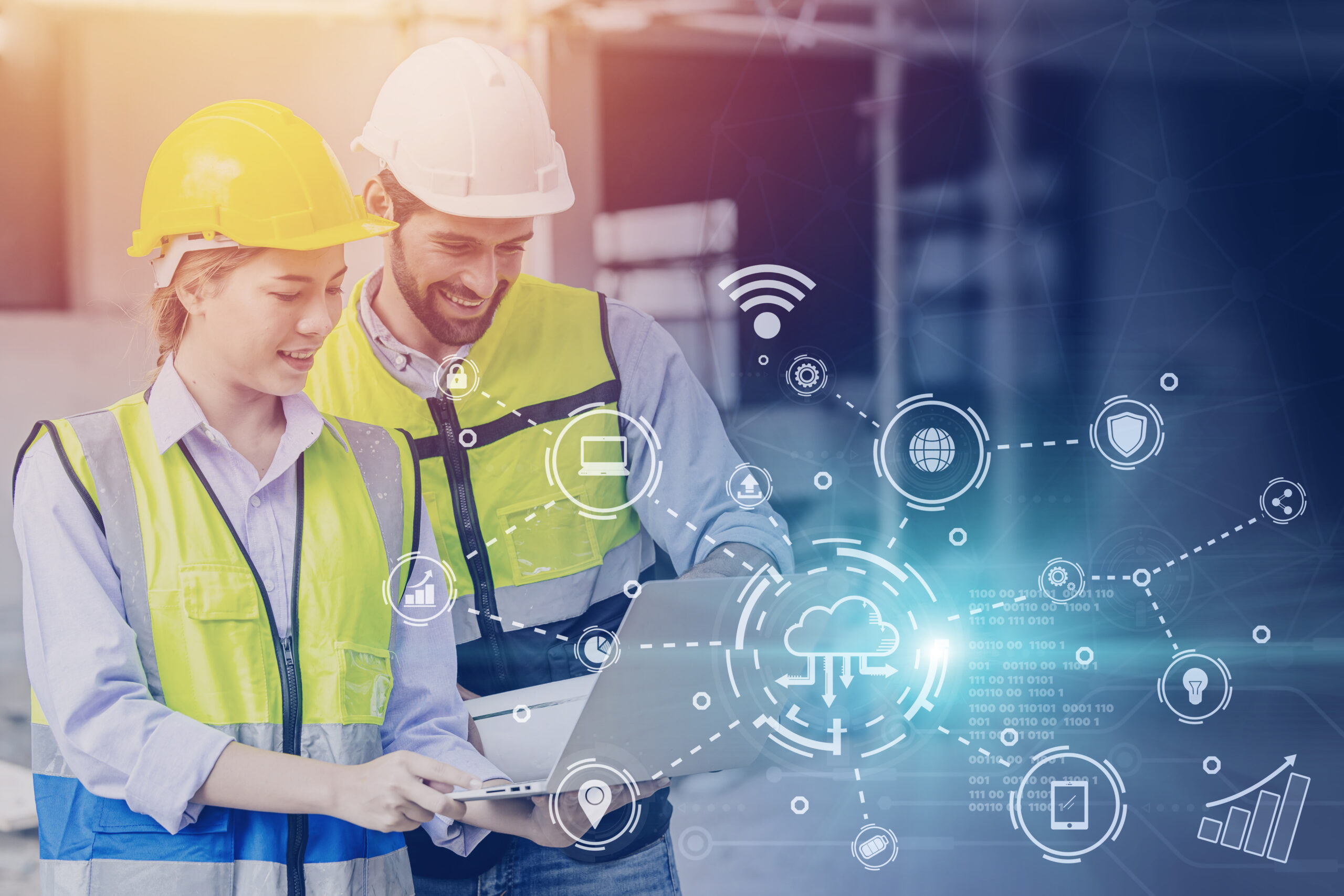 Two construction workers look at a computer with graphics of different business IT icons to represent construction technology.