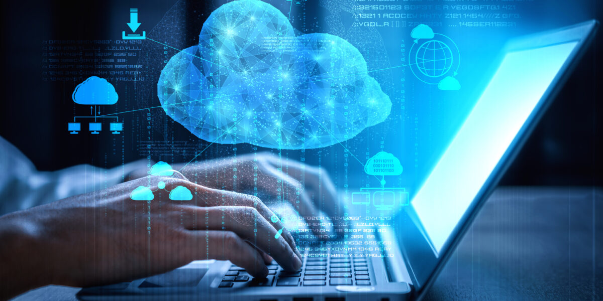 A women typing on a laptop with a graphic of a large cloud with smaller icons around it to represent cloud services.